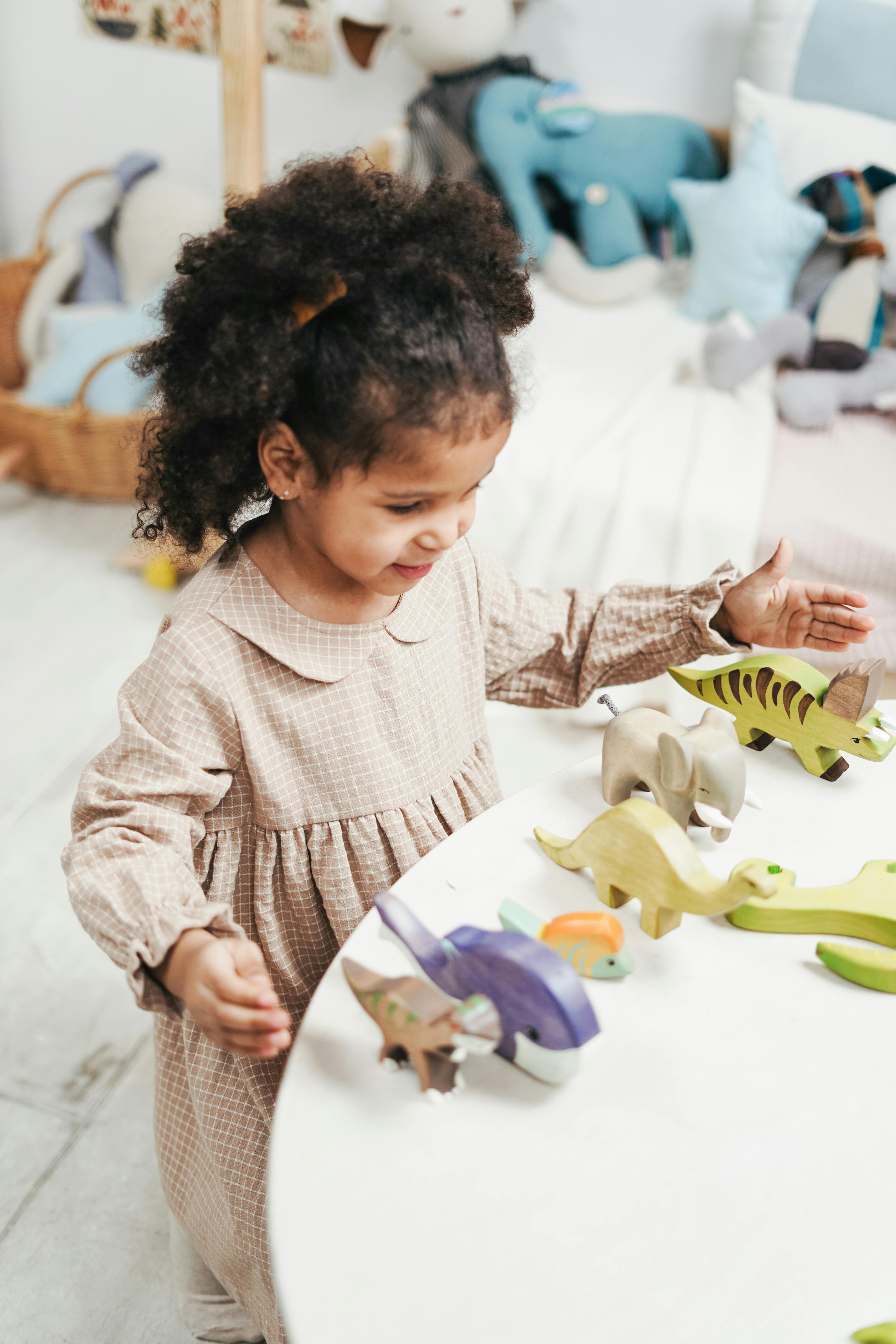 Selective Focus Photo of Young Girl Playing with Wooden Toys on White Table