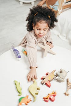 孩子在舒适的房间里快乐地玩着色彩缤纷的木制动物玩具