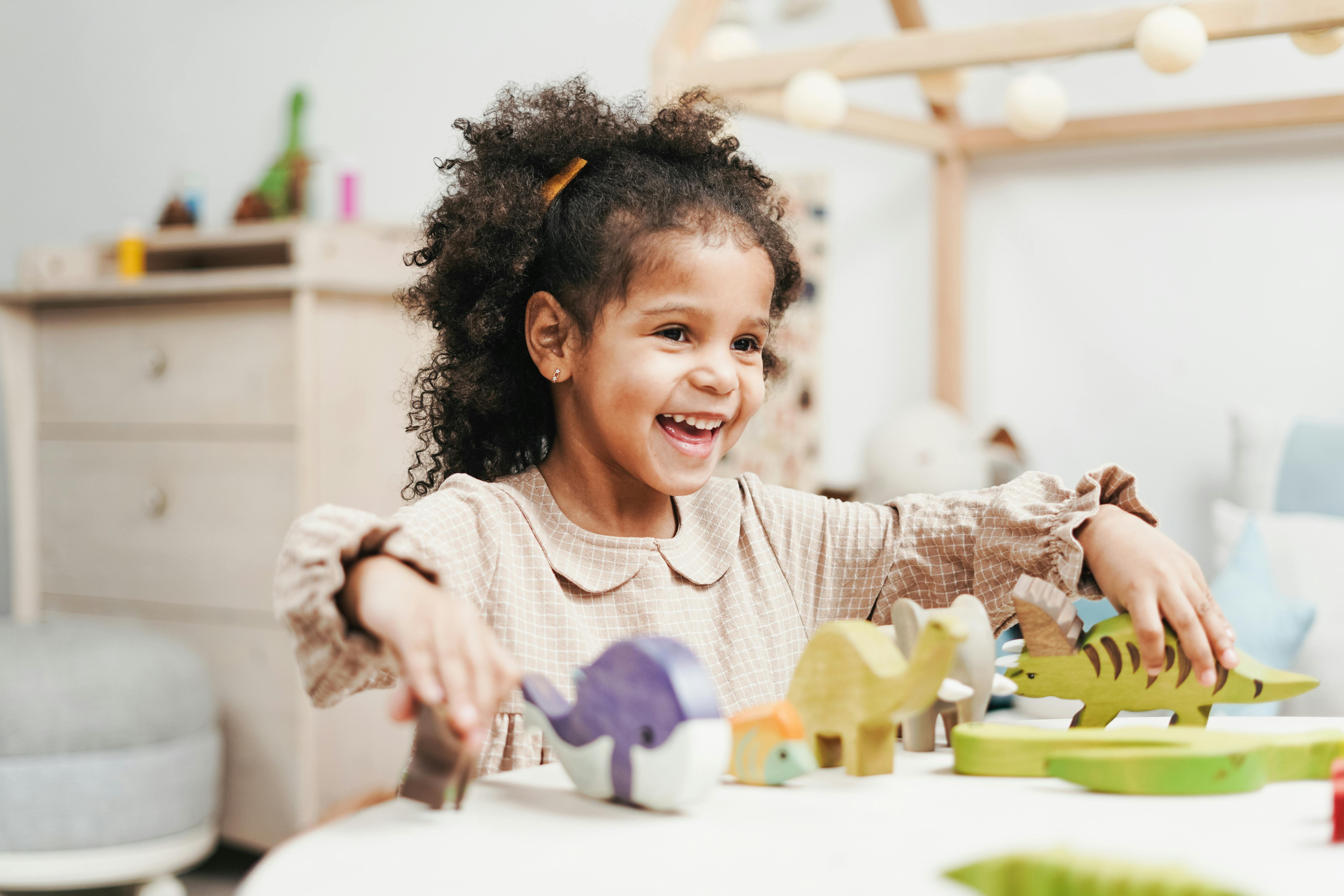 Little girl playing with wooden toys on a table. | Photo: Pexels 