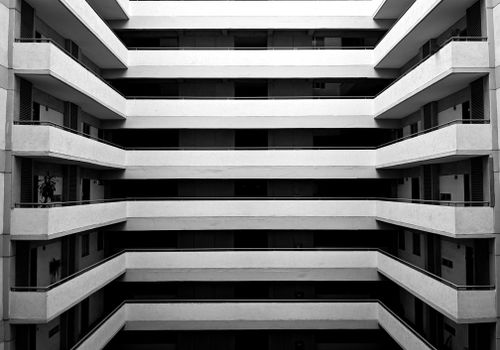 Free A striking black and white view of a symmetrical apartment building's balconies. Stock Photo