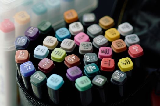 Close-up of a colorful array of art markers in different shades and labels.