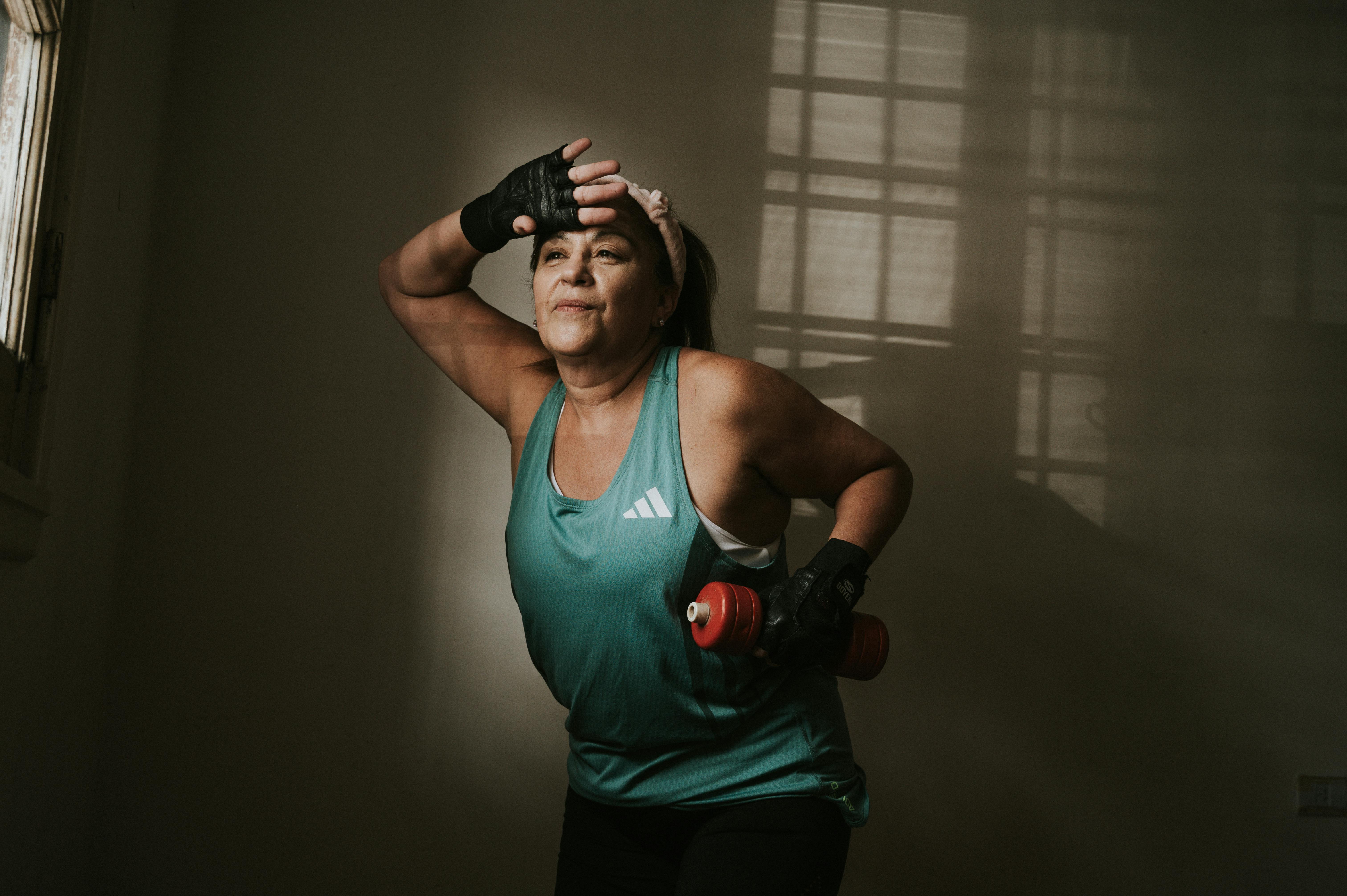 Zadarmo Žena stredného veku cvičí s činkou v interiéri. Koncept fitness a zdravého životného štýlu. Fotka z fotobanky