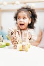 一个快乐的卷发孩子喜欢在明亮的室内玩木制玩具