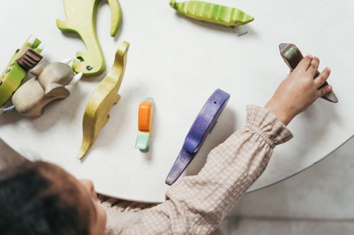 Free Child playing with colorful wooden toys in a playful indoor setting. Stock Photo