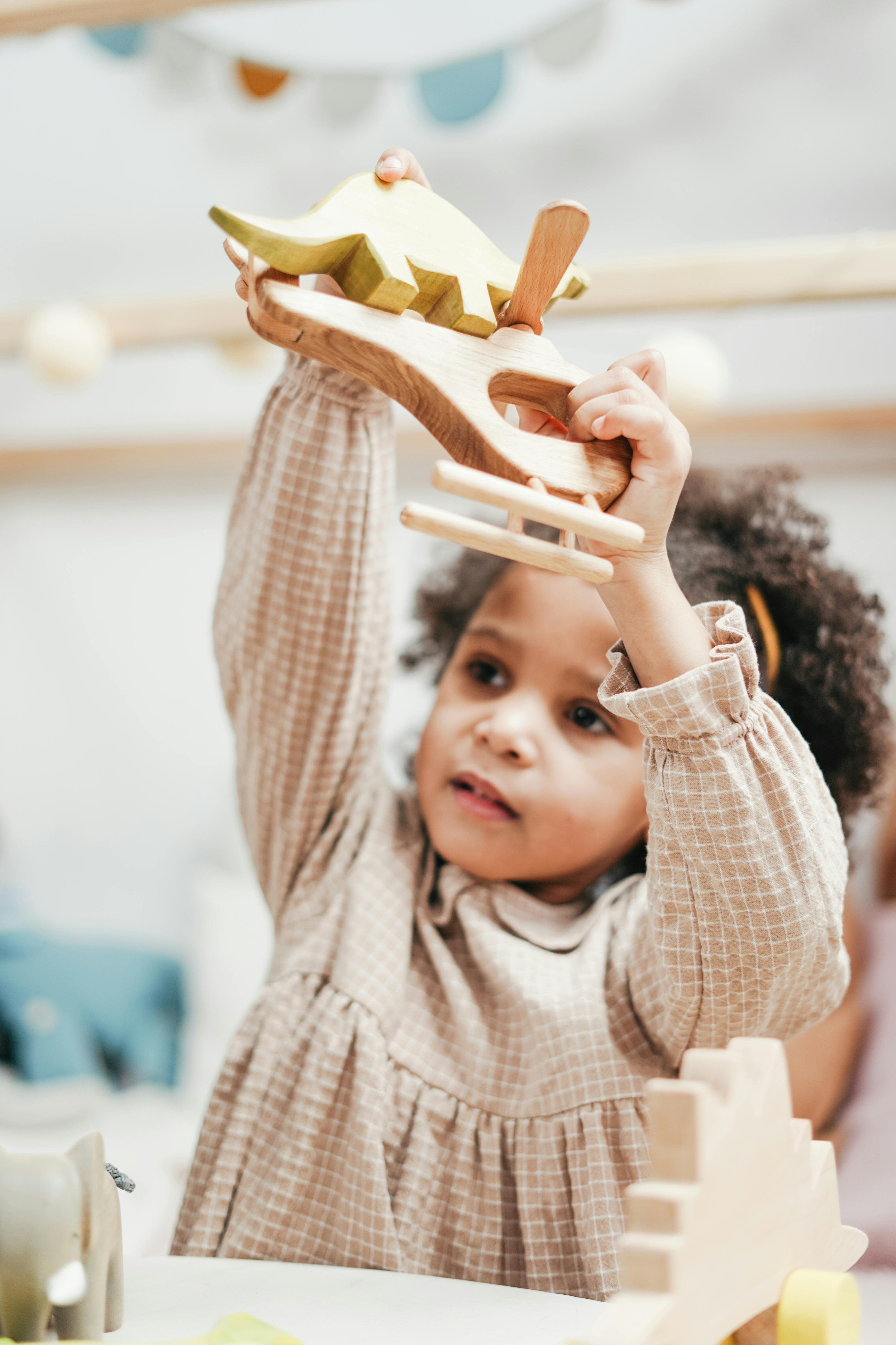 girl holding wooden toys