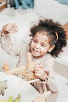 一个快乐的女孩留着非洲发型，在舒适的房间里开心地玩着木制玩具