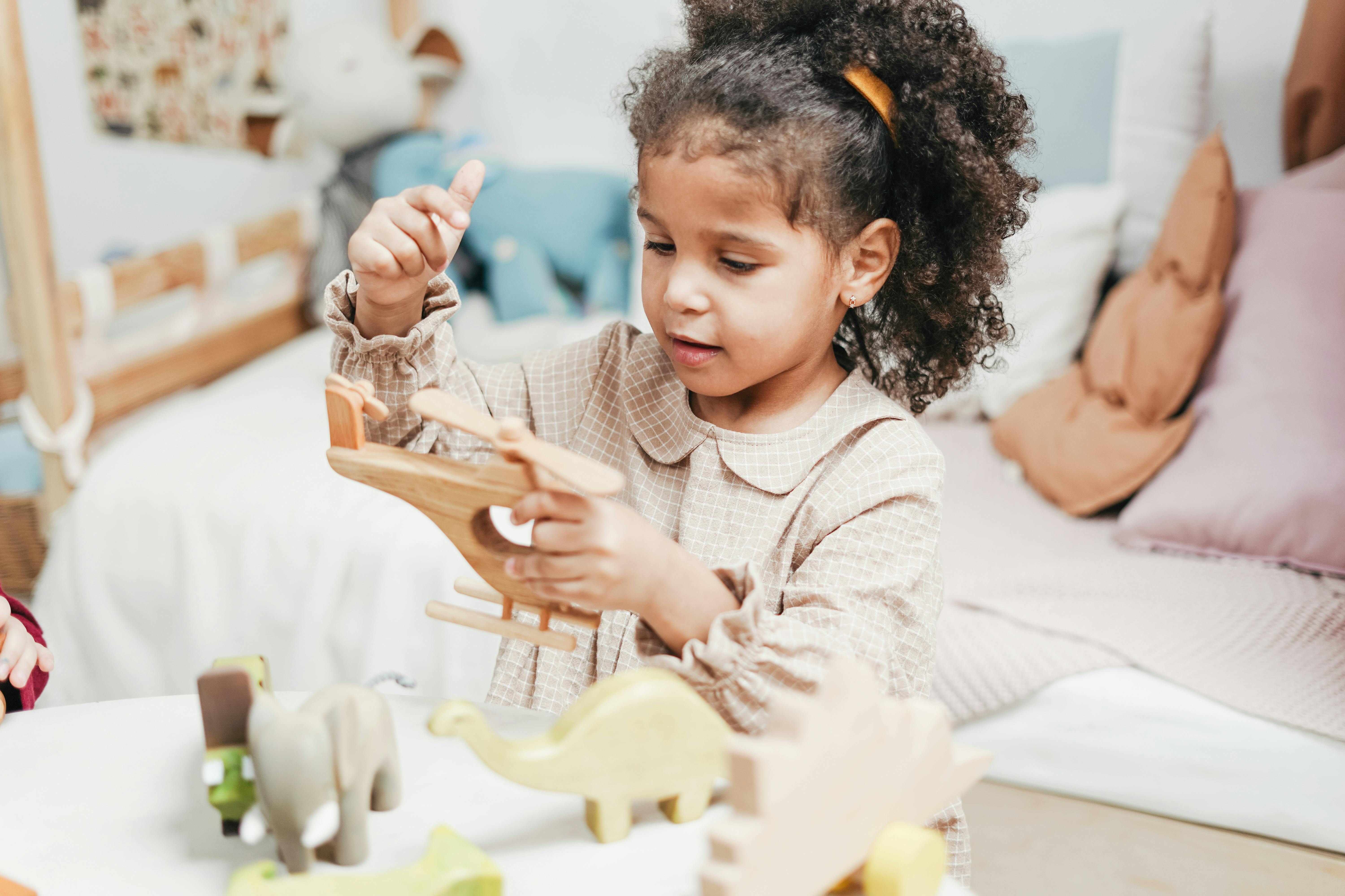 girl playing with wooden helicopter toy