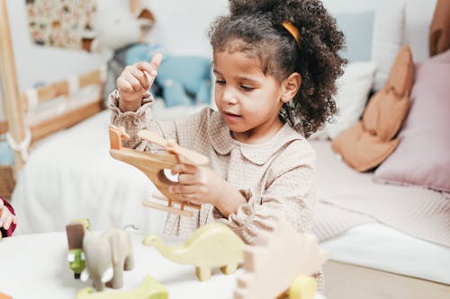 Free Girl Playing With Wooden Helicopter Toy Stock Photo