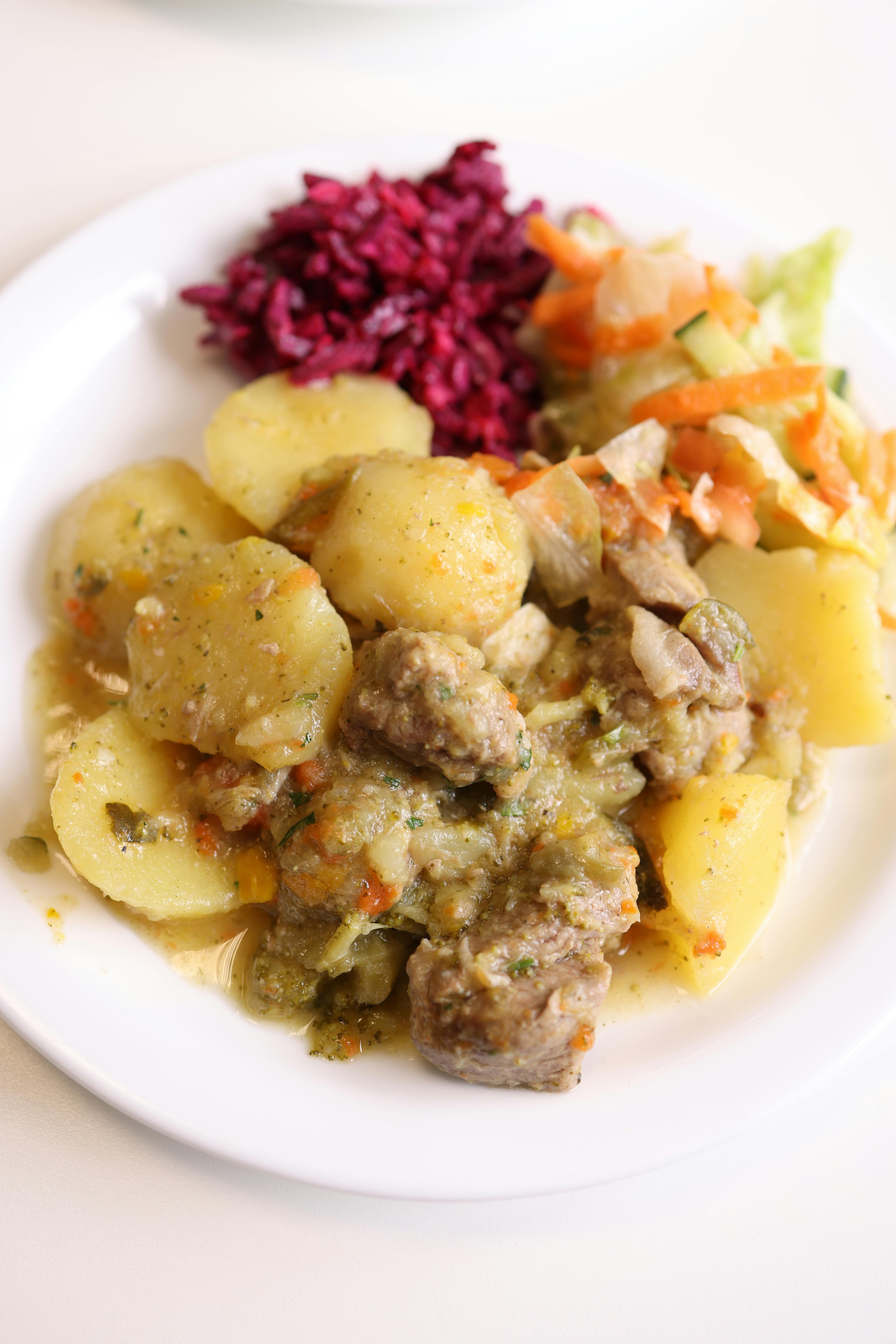 Appetizing dish featuring roasted lamb with potatoes and vibrant salads.