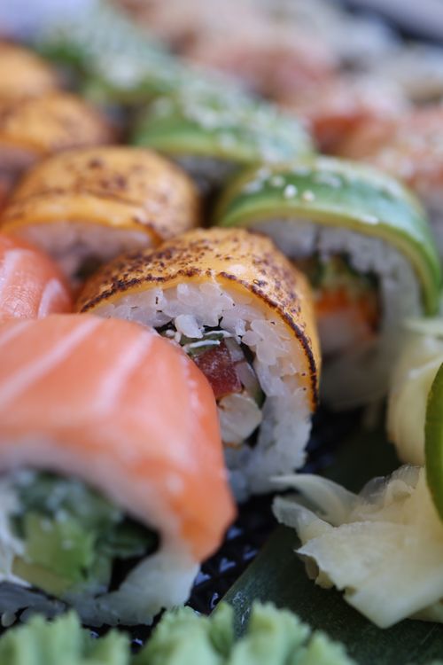 Free A detailed close-up of assorted sushi rolls featuring fresh salmon and avocado. Stock Photo