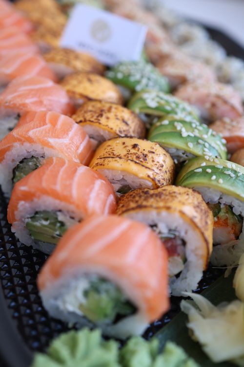 Free Delicious variety of fresh sushi rolls with salmon, avocado, and more on a platter. Stock Photo