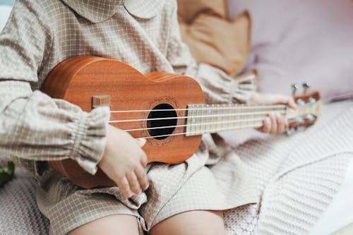 бесплатная Фотография малыша, играющего на укулеле Стоковое фото