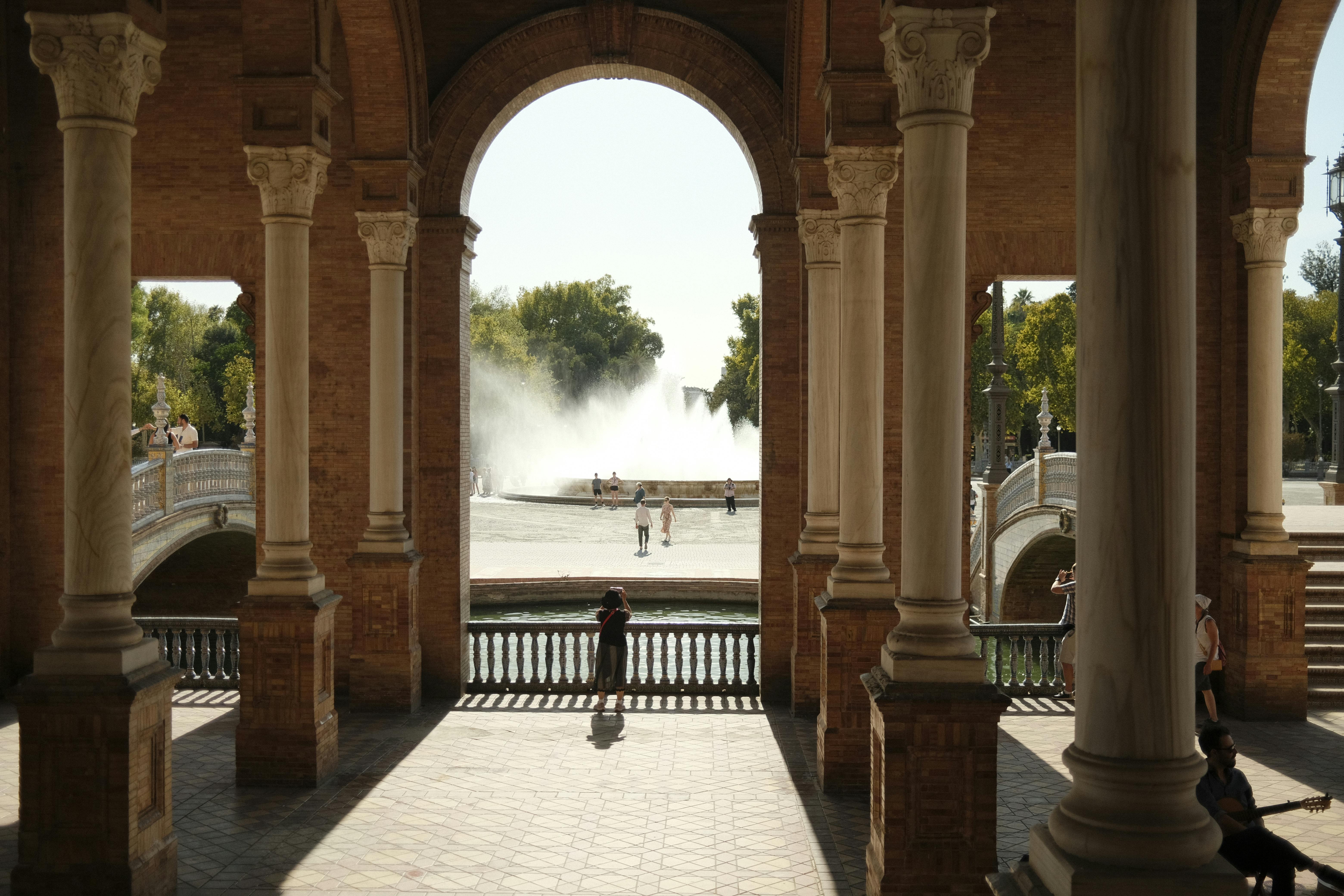 ฟรี ภาพทิวทัศน์สถาปัตยกรรมอันงดงามพร้อมน้ำพุที่จัตุรัสพลาซา เด เอสปาญา ในเมืองเซบียา ประเทศสเปน คลังภาพถ่าย