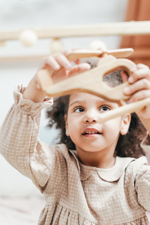 Girl Playing with Wooden Helicopter