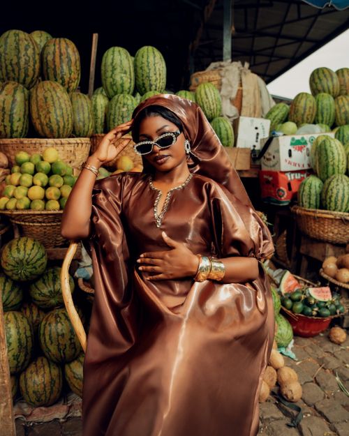 Free Stylish woman in market with fruit displays elegance and culture. Stock Photo