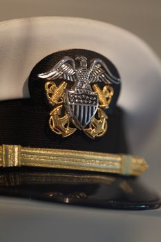 Detailed view of a naval officer's hat showcasing the intricate insignia design symbolizing rank and authority.