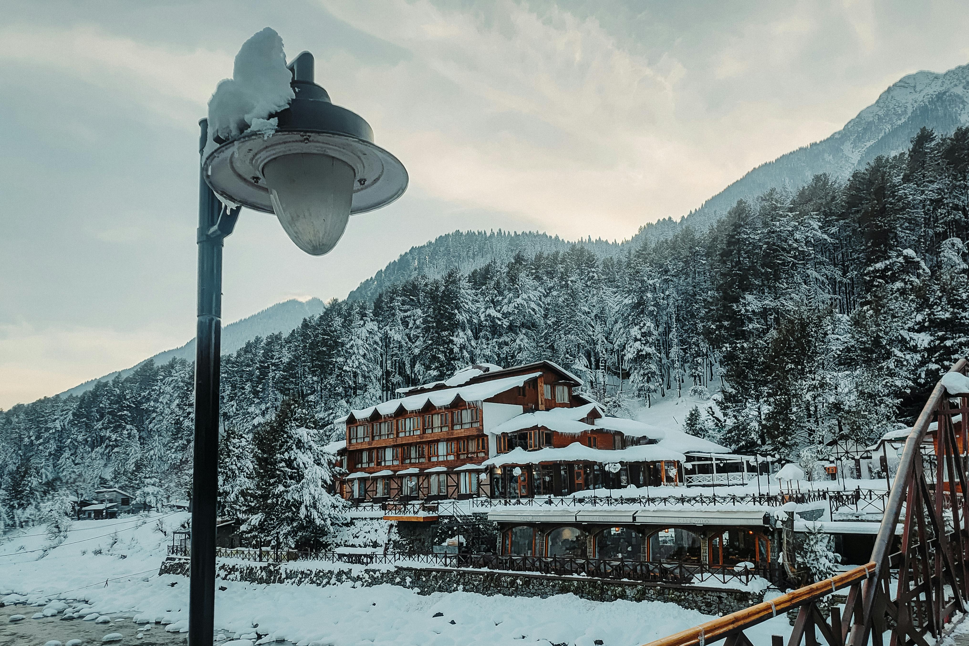 ingyenes Egy hófödte táj Pahalgamban, rusztikus épülettel és hófödte fákkal. Stockfotó