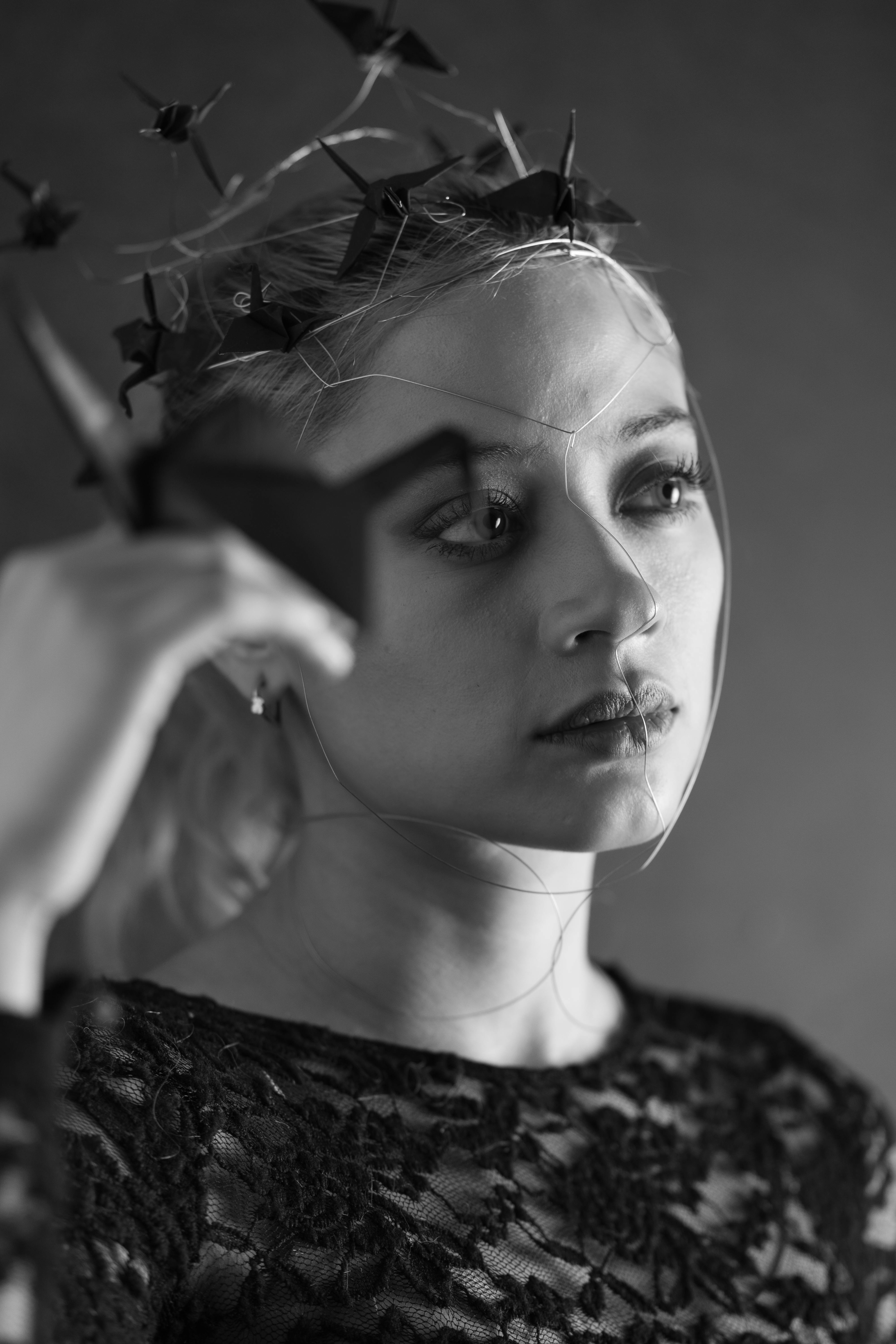 免費 一幅黑白高對比肖像畫，畫中女子身上裝飾著金屬網和摺紙藝術品。 圖庫相片