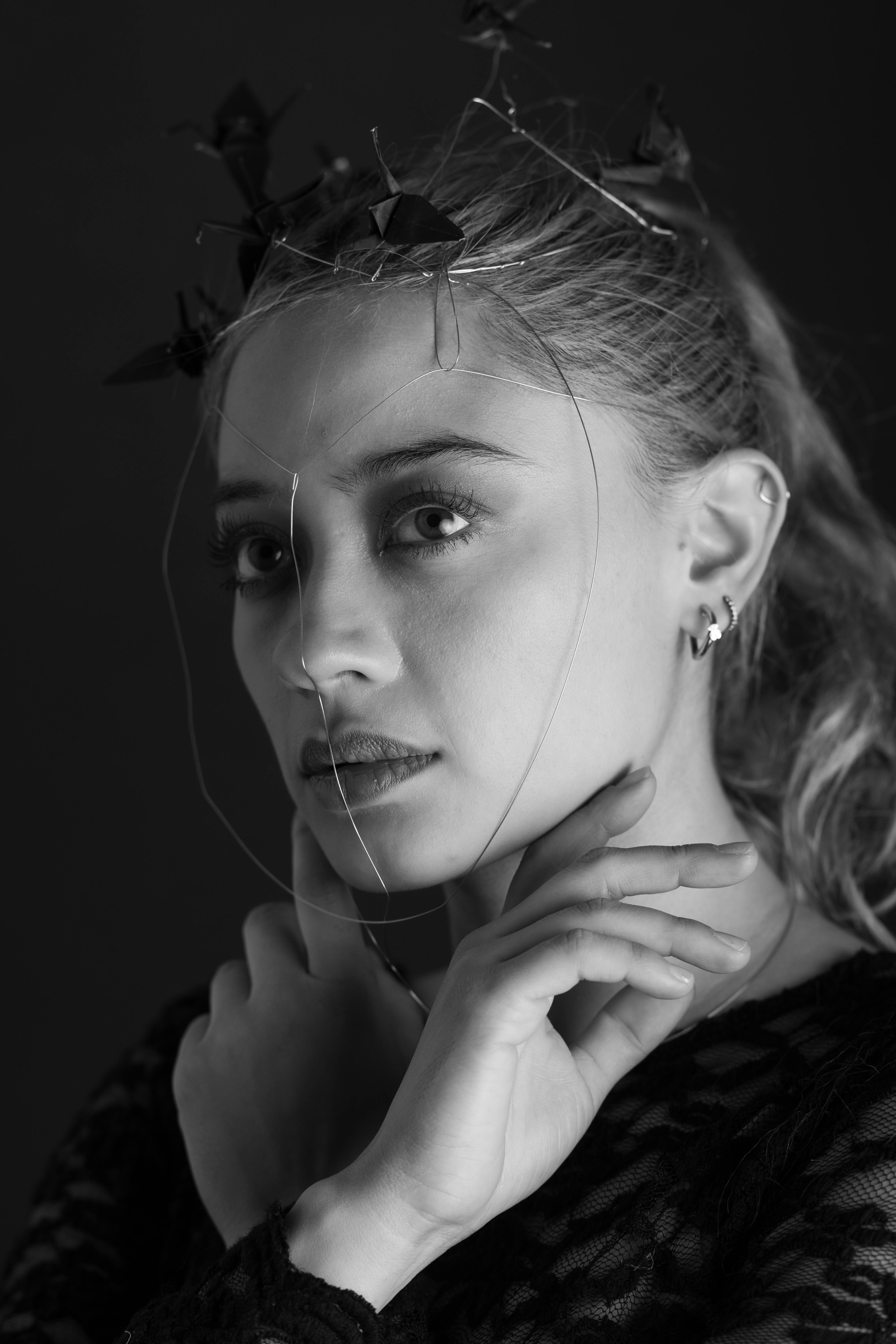 ingyenes Fekete-fehér portré egy drótból készült maszkot viselő nőről, hangulatos és művészi esztétikát sugározva. Stockfotó