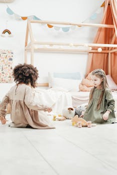 两个年轻女孩在明亮舒适的游戏室里玩着木制玩具