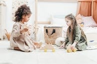 两个年轻女孩喜欢在舒适的游戏室里玩木制玩具