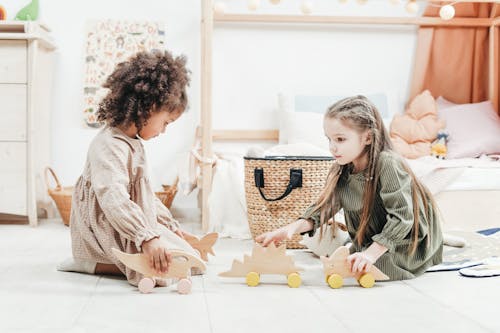 Фотография девочек, играющих с деревянными игрушками