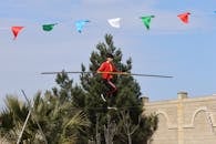Tightrope Walker Balancing Outdoors with Banner Flags