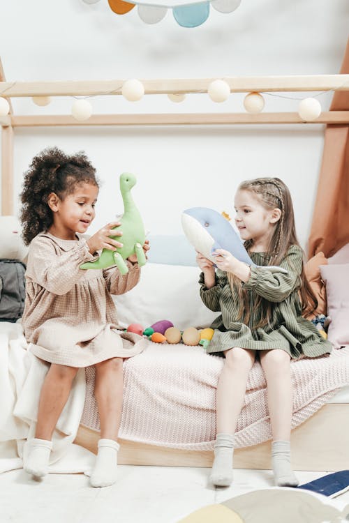 Фотография двух девушек, играющих с мягкими игрушками