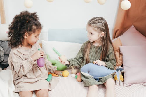Free Siblings Sharing Their Toy to Each Other Stock Photo