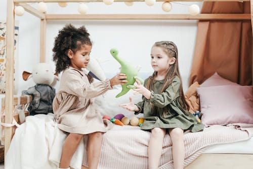 Братья и сестры играют в зеленые плюшевые игрушки