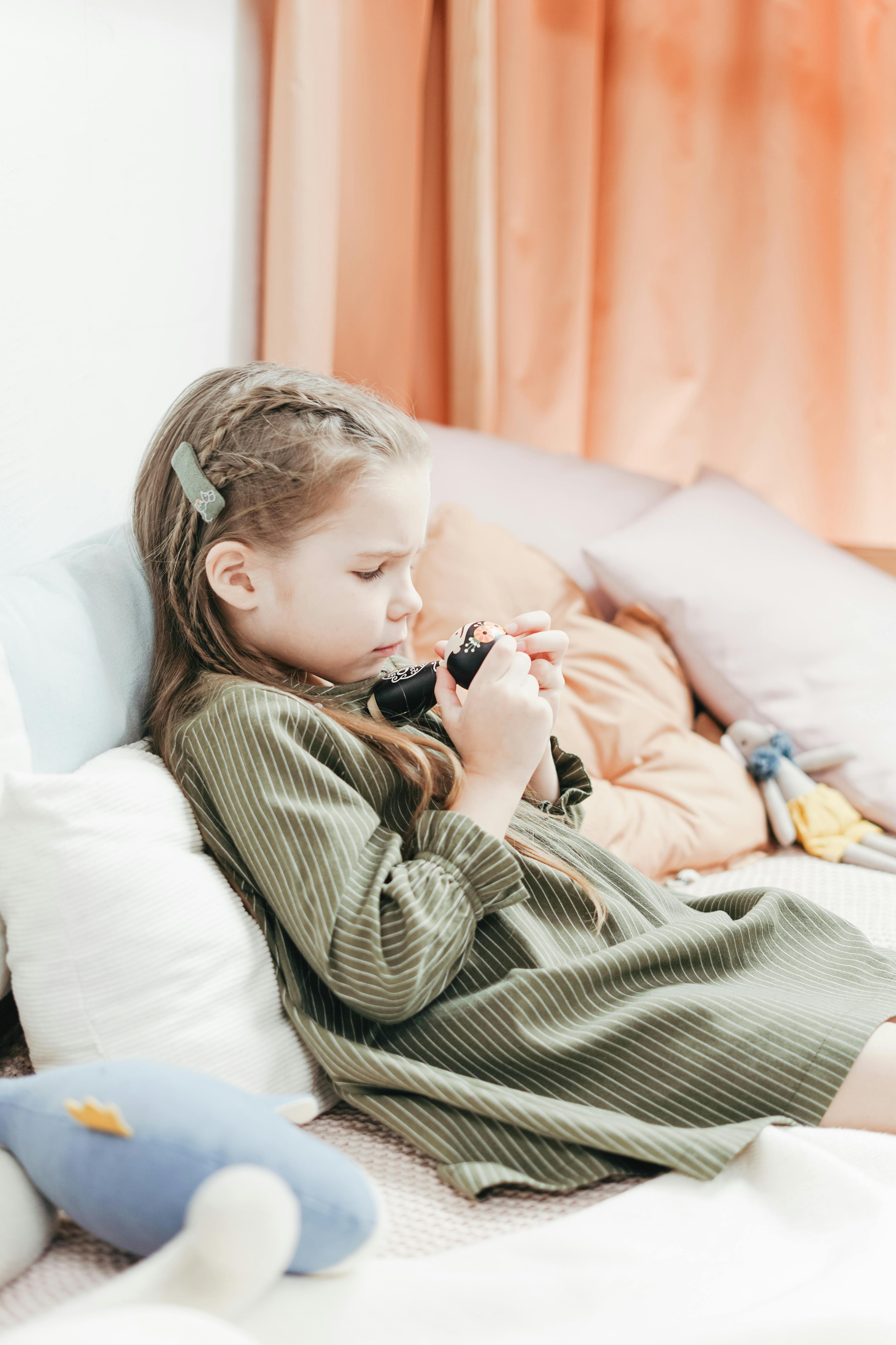 girl in green and white stripe long sleeve dress lying on bed