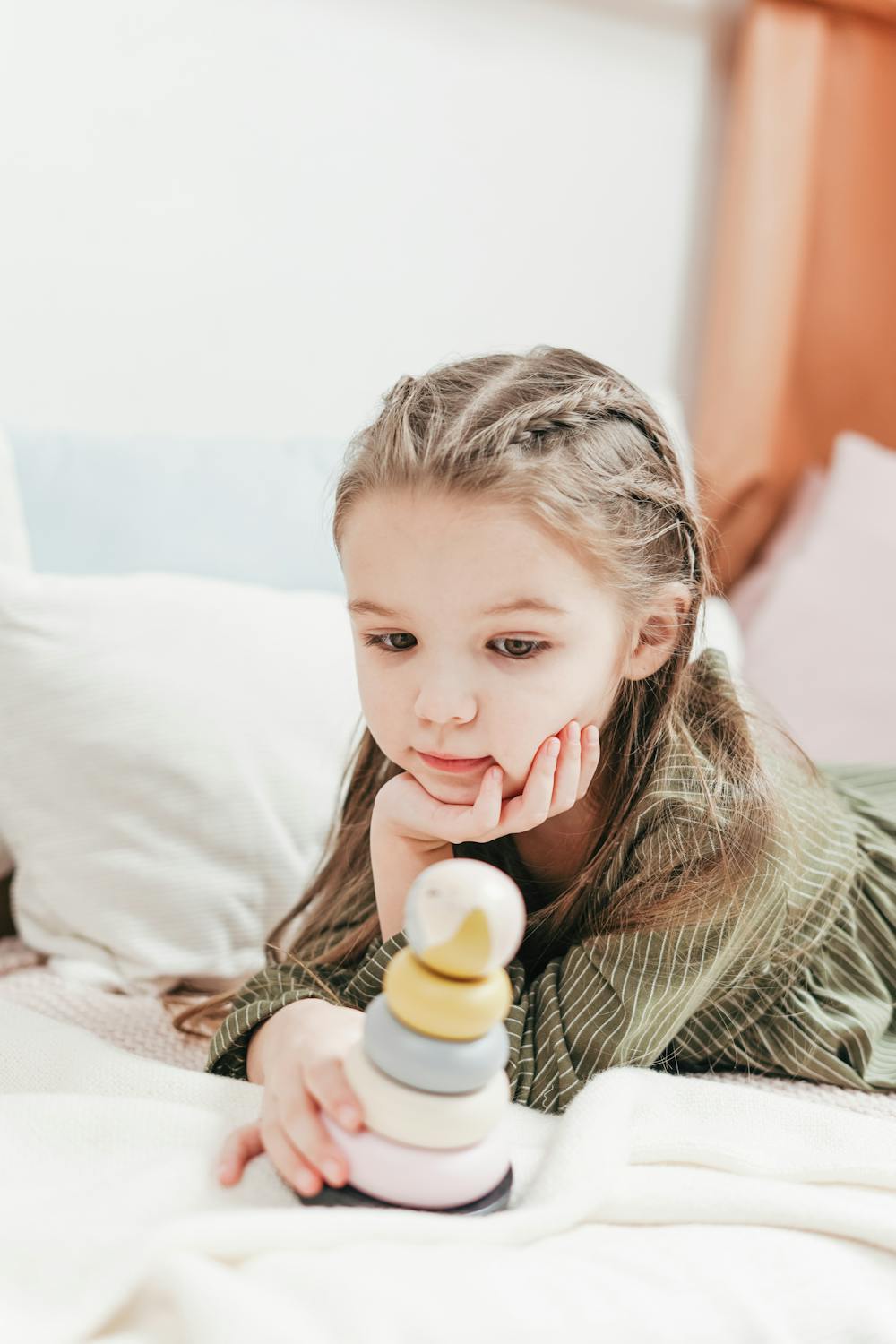 A young child playing with wooden toys, representing the nurturing environment Momitor helps create