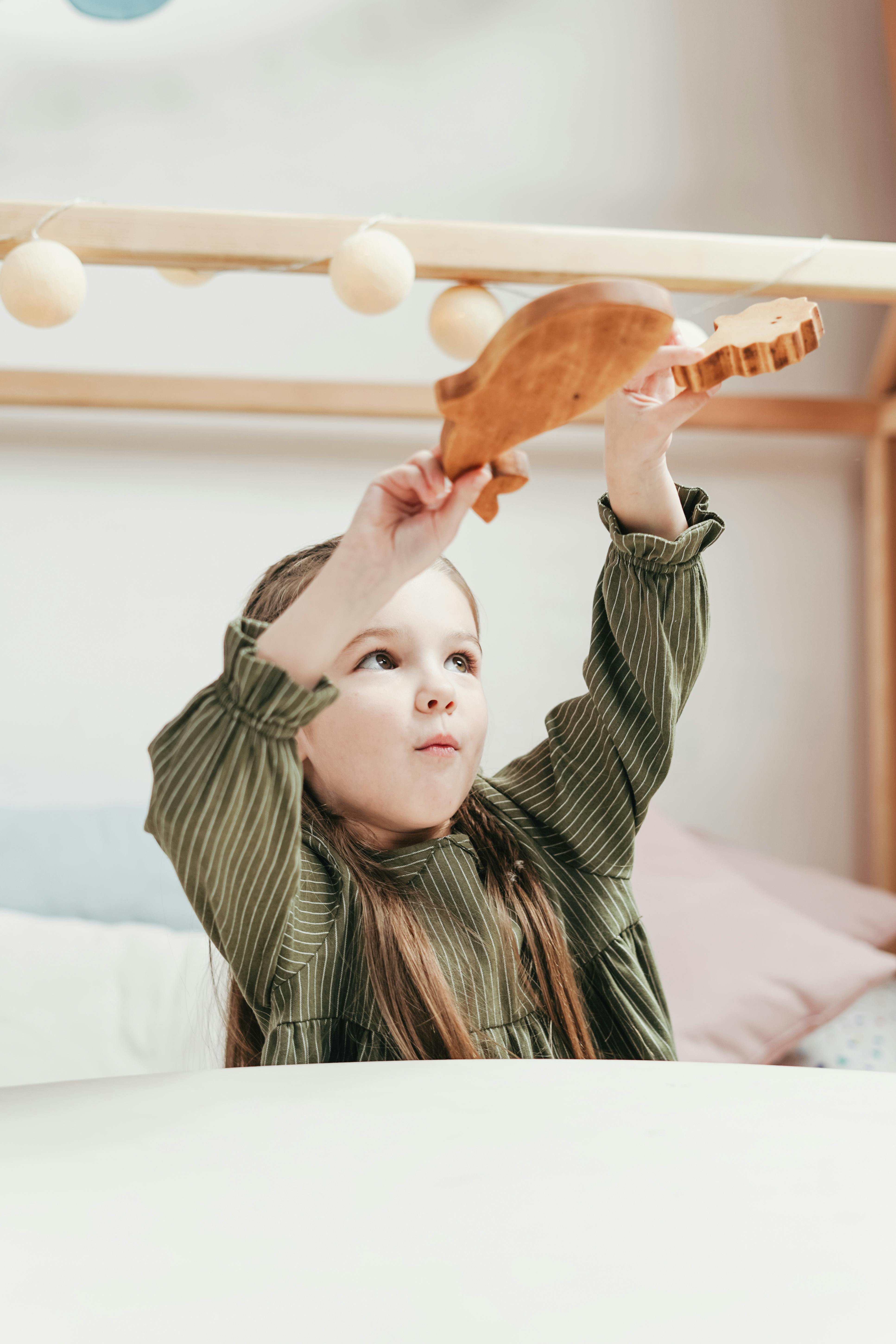 一个孩子在室内快乐地玩着木制玩具，充满乐趣和创造力