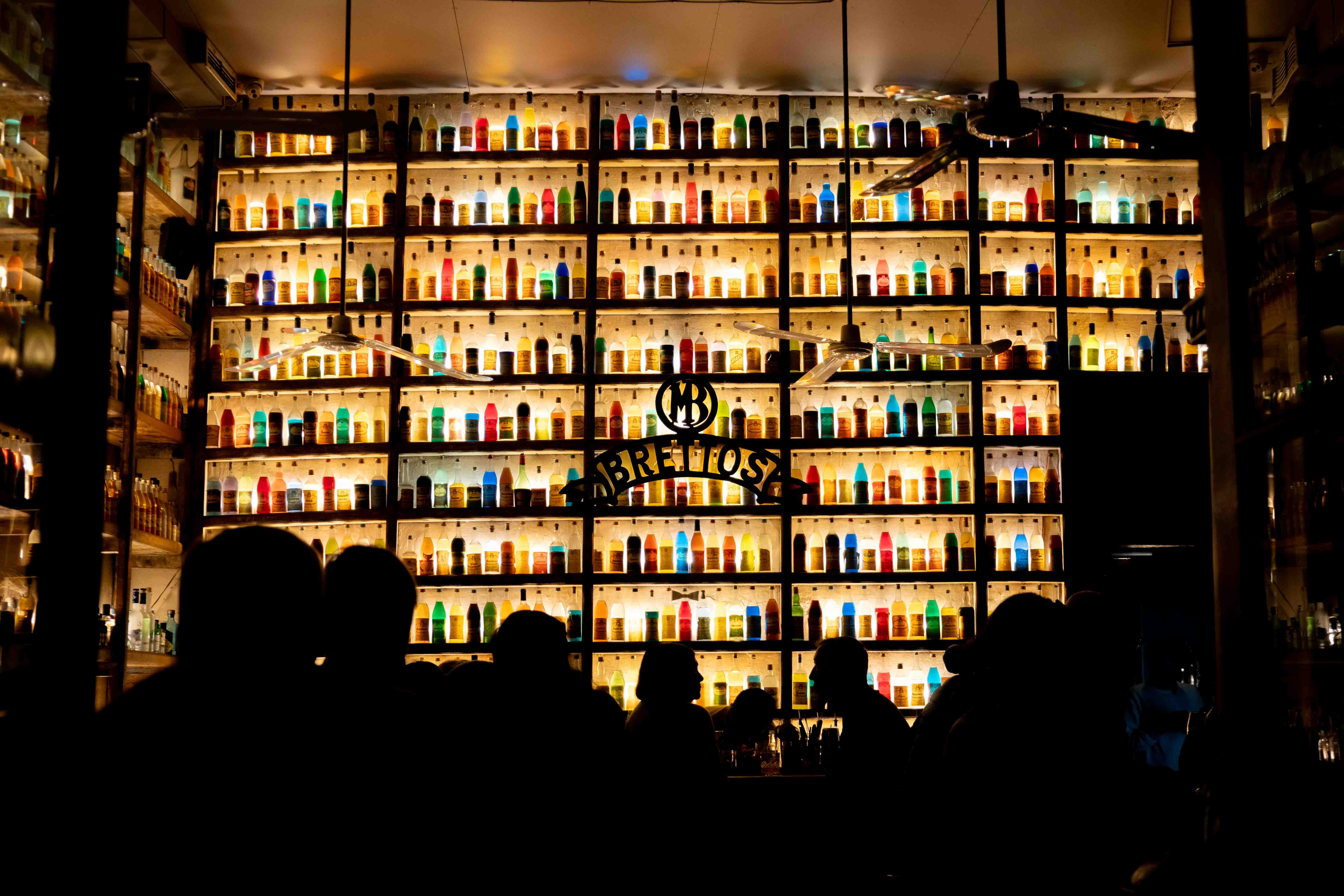 Gazi Athens nightlife clubs bars - colorful bar scene with bottles and silhouettes