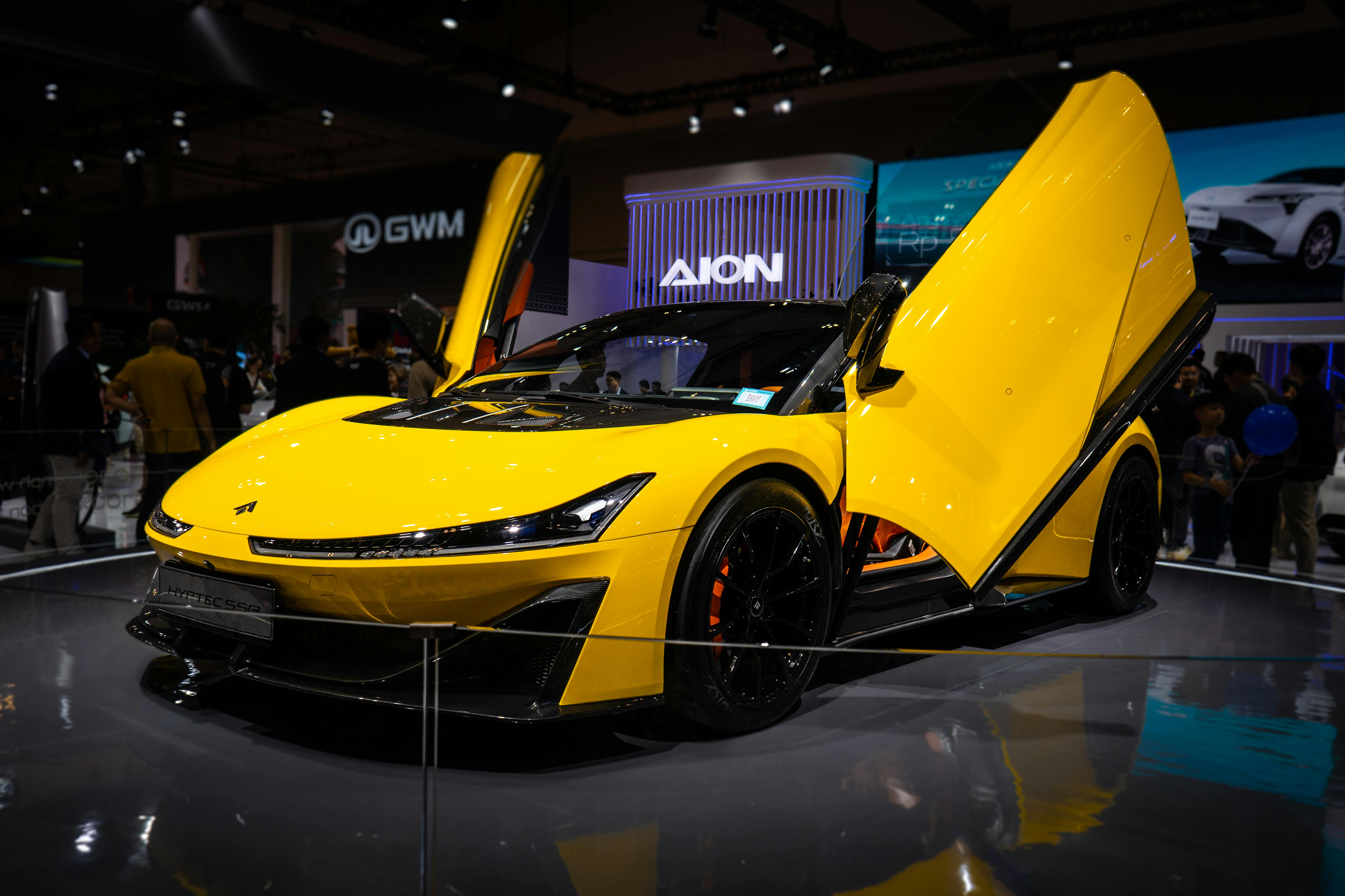 Zadarmo Žlté športové auto s krídlovými dverami vystavené na krytej automobilovej výstave. Fotka z fotobanky