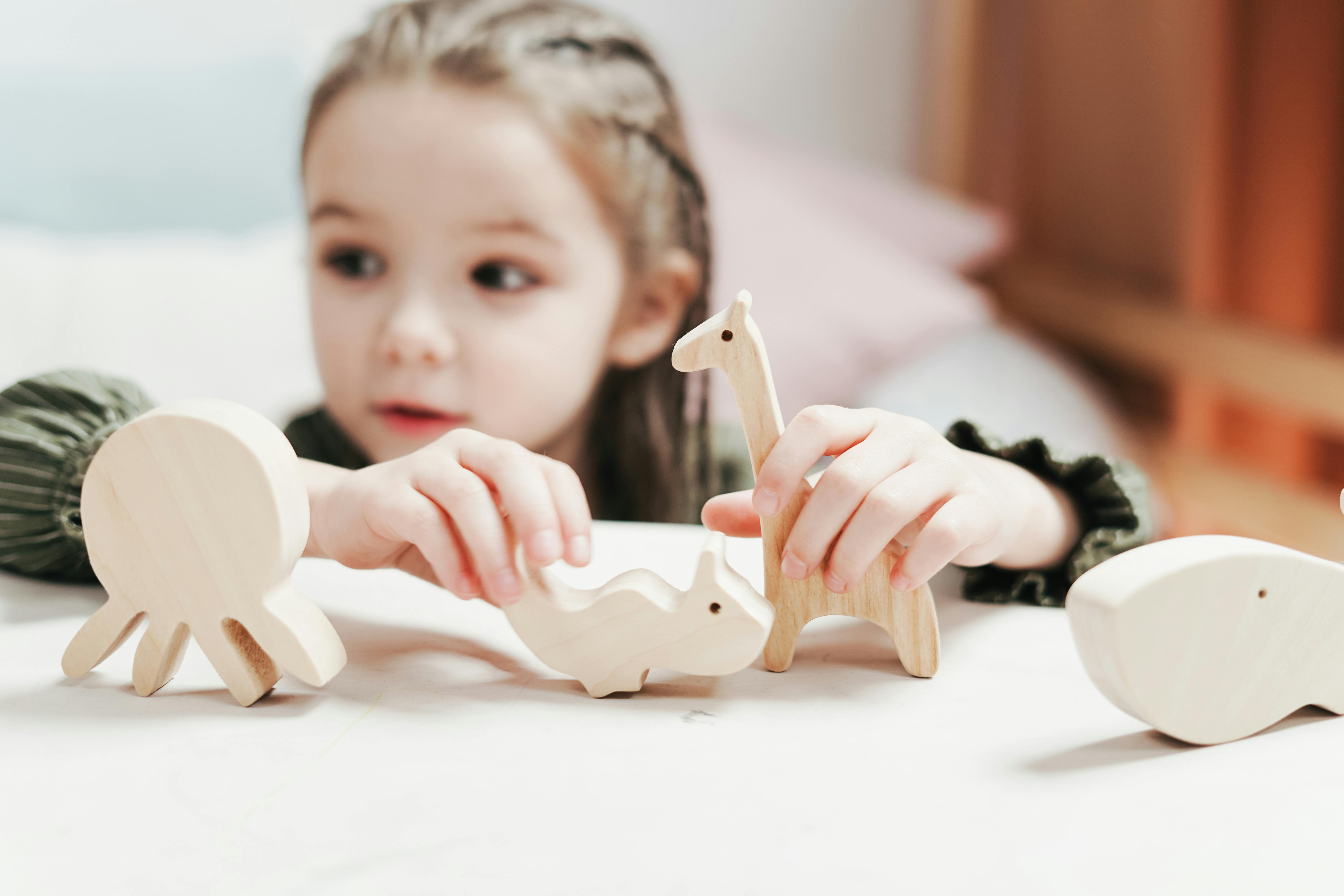 boygirl holding wooden toys