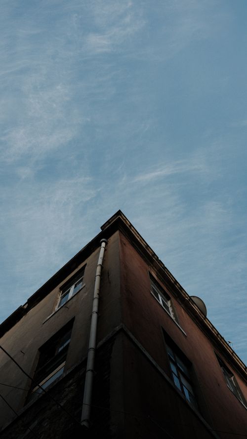Free Low angle view of an urban building corner with a dramatic sky backdrop, perfect for architectural or abstract themes. Stock Photo