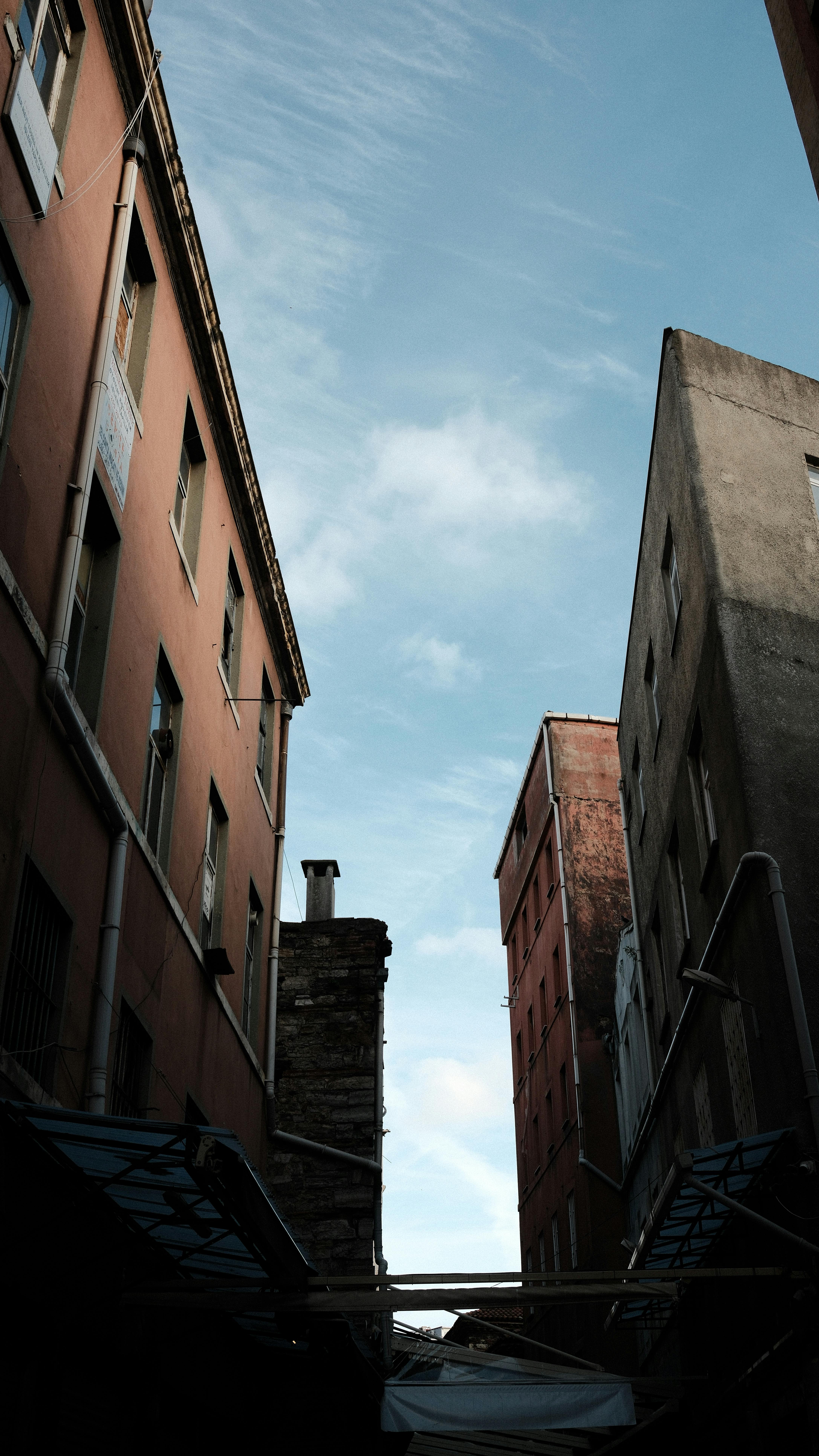 ingyenes Kilátás a városi épületek között, bemutatva az eget és az építészeti részleteket. Stockfotó