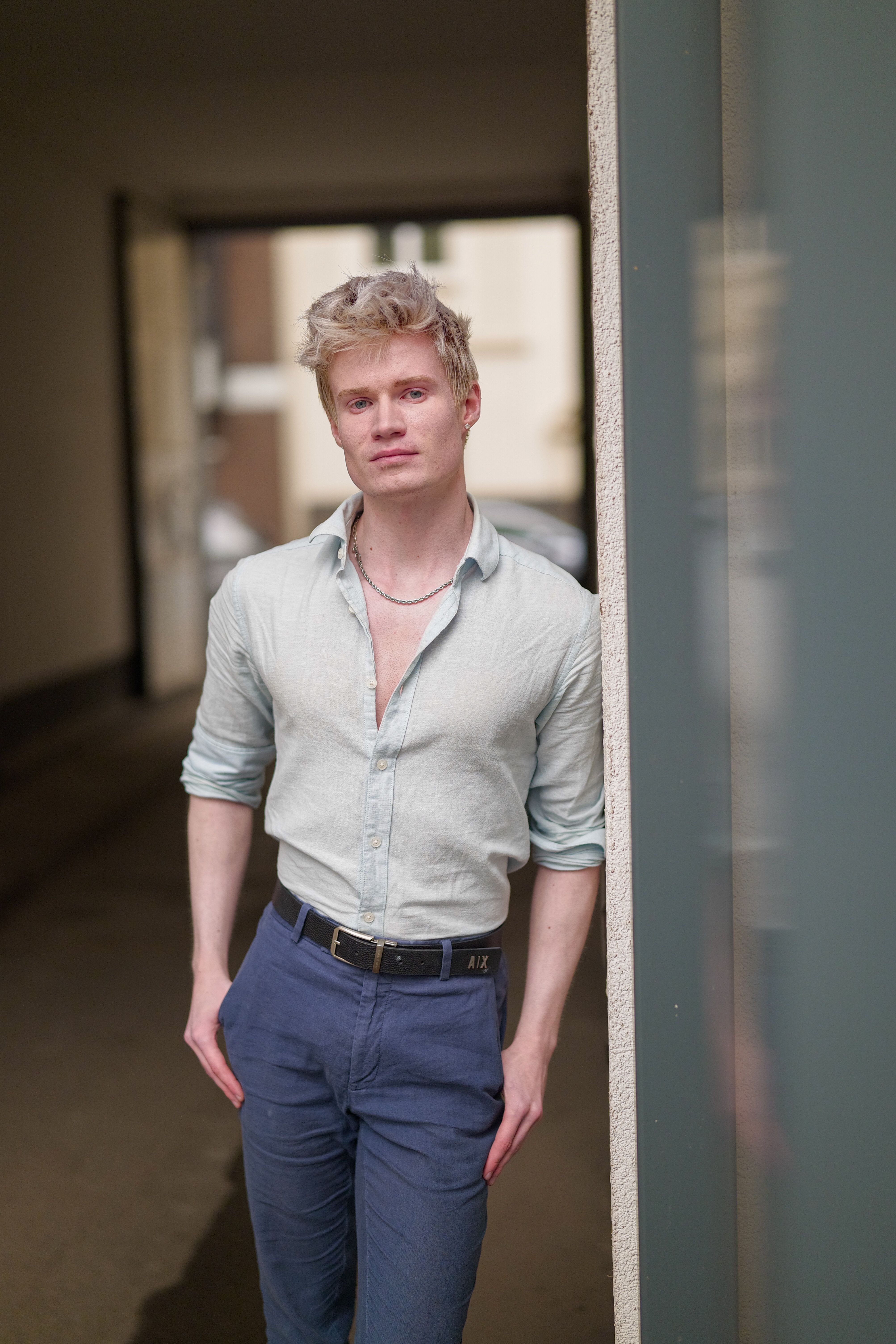Portrait of a stylish young man standing in an alleyway in Düsseldorf, Germany.