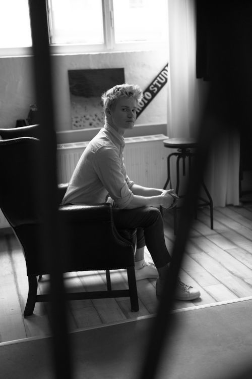 Free Artistic black and white portrait of a person seated in a Düsseldorf studio setting. Stock Photo