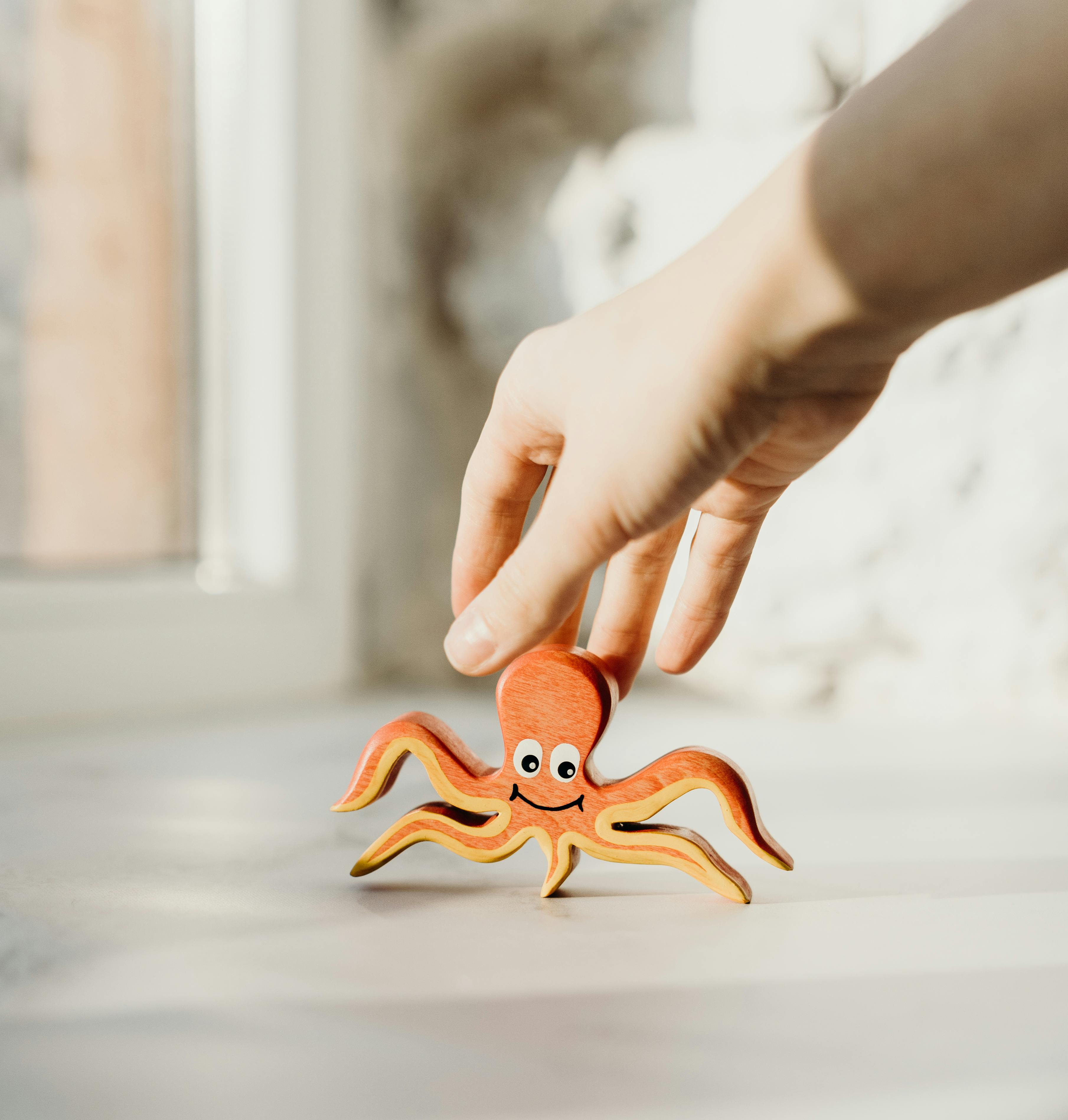 Person Holding Wooden Octopus Toy · Free Stock Photo