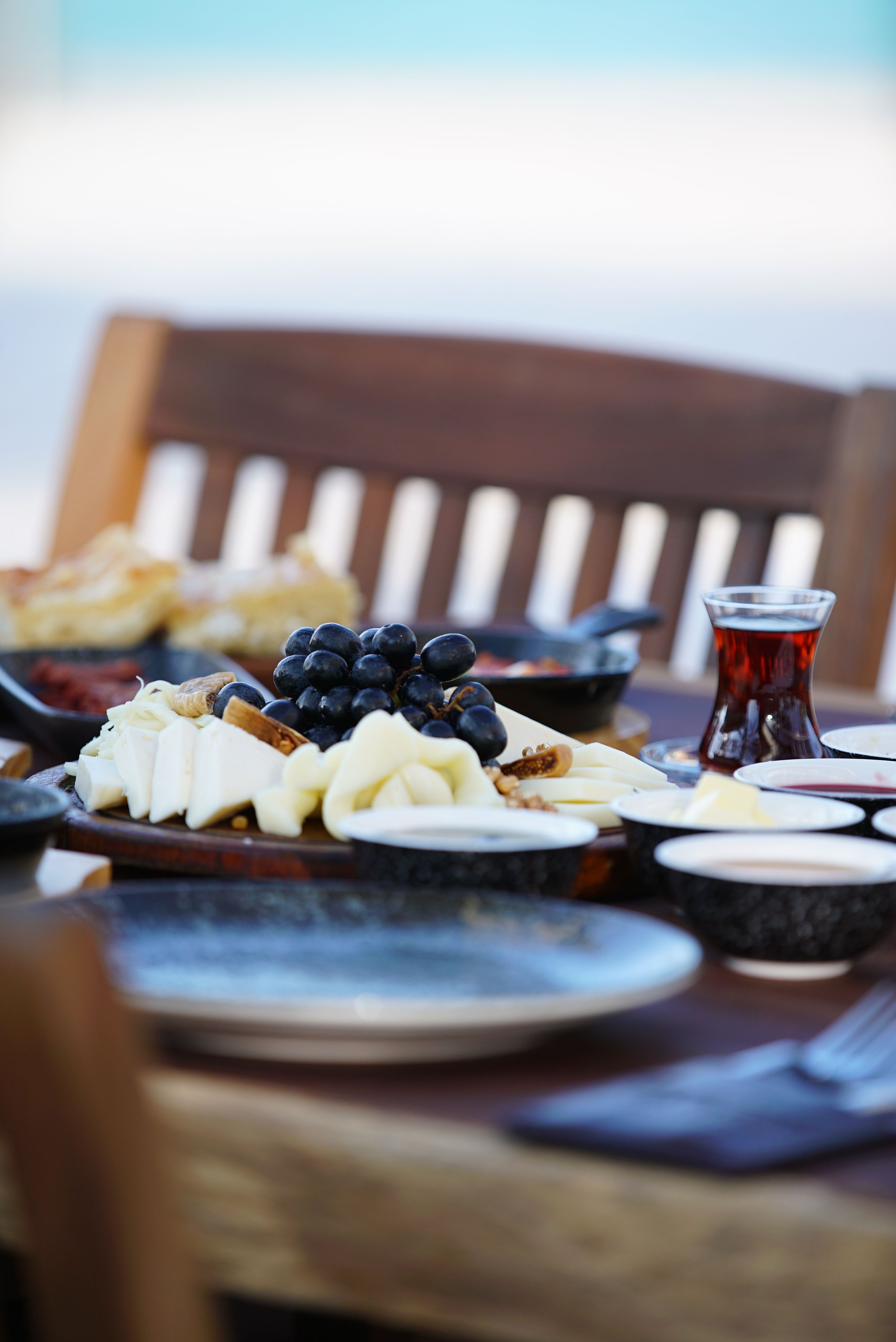 Charming outdoor dining setup featuring a cheese platter, grapes, and tea.