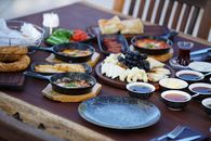 A colorful traditional Turkish breakfast spread with a variety of dishes and tea outdoors.