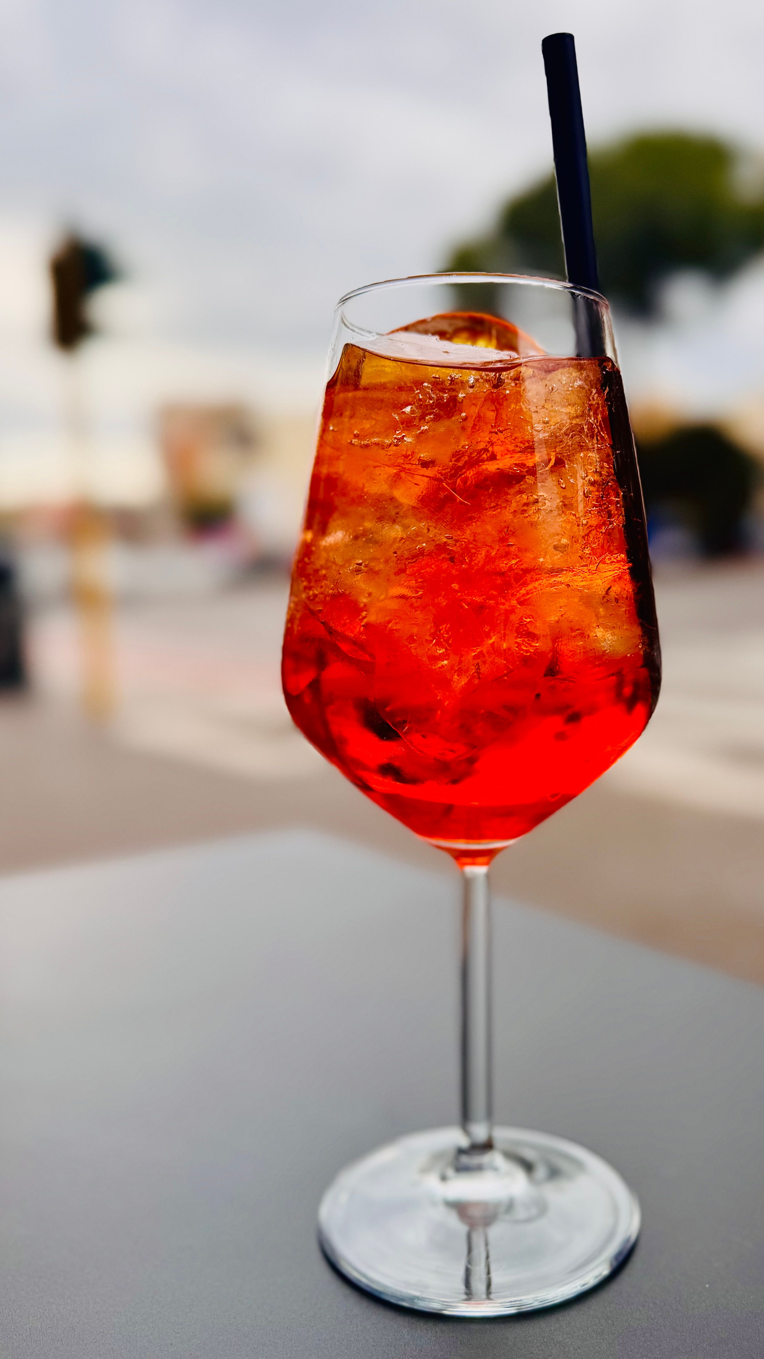 Gratis Lys og forfriskende Aperol Spritz-cocktail med is, servert utendørs med en uskarp bakgrunn. Arkivbilde