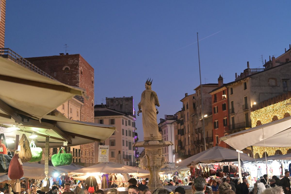 Piazza delle Erbe la amurg, cu tarabe si ghirlande luminoase