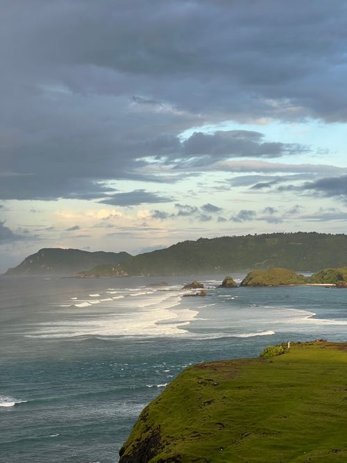 Free Breathtaking coastal landscape of Nusa Tenggara Barat, Indonesia with waves and lush greenery. Stock Photo
