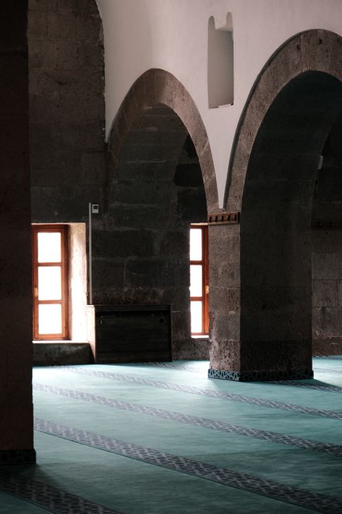 Free Interior view of an ancient building with stone arches and sunlight through windows. Stock Photo