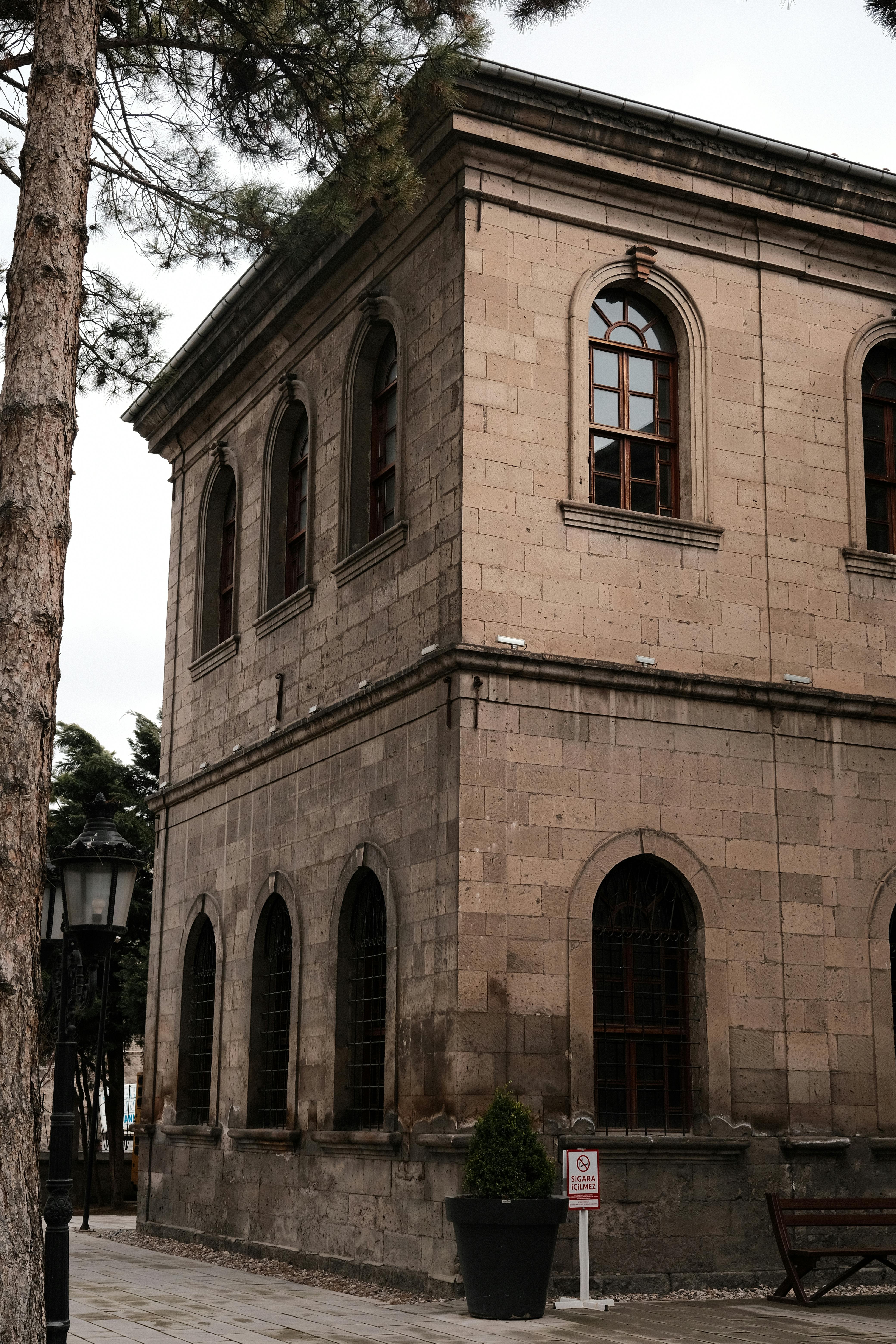 무료 아치형 창문이 있는 고전적인 석조 건물이 도심 환경에 자리 잡고 있어 건축 유산을 돋보이게 합니다. 스톡 사진