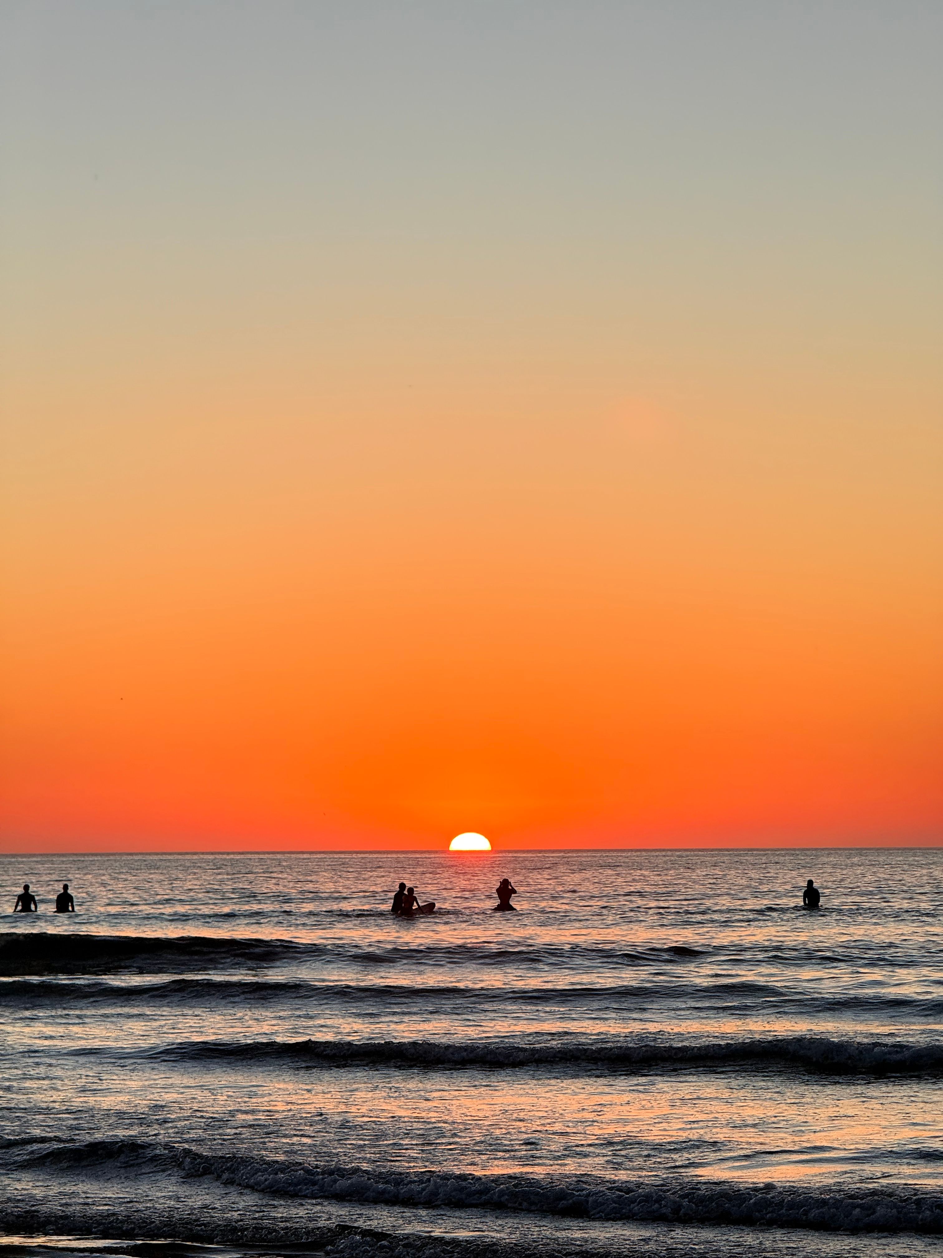 Surfers Enjoying a Vibrant Sunset at the Beach · Free Stock Photo