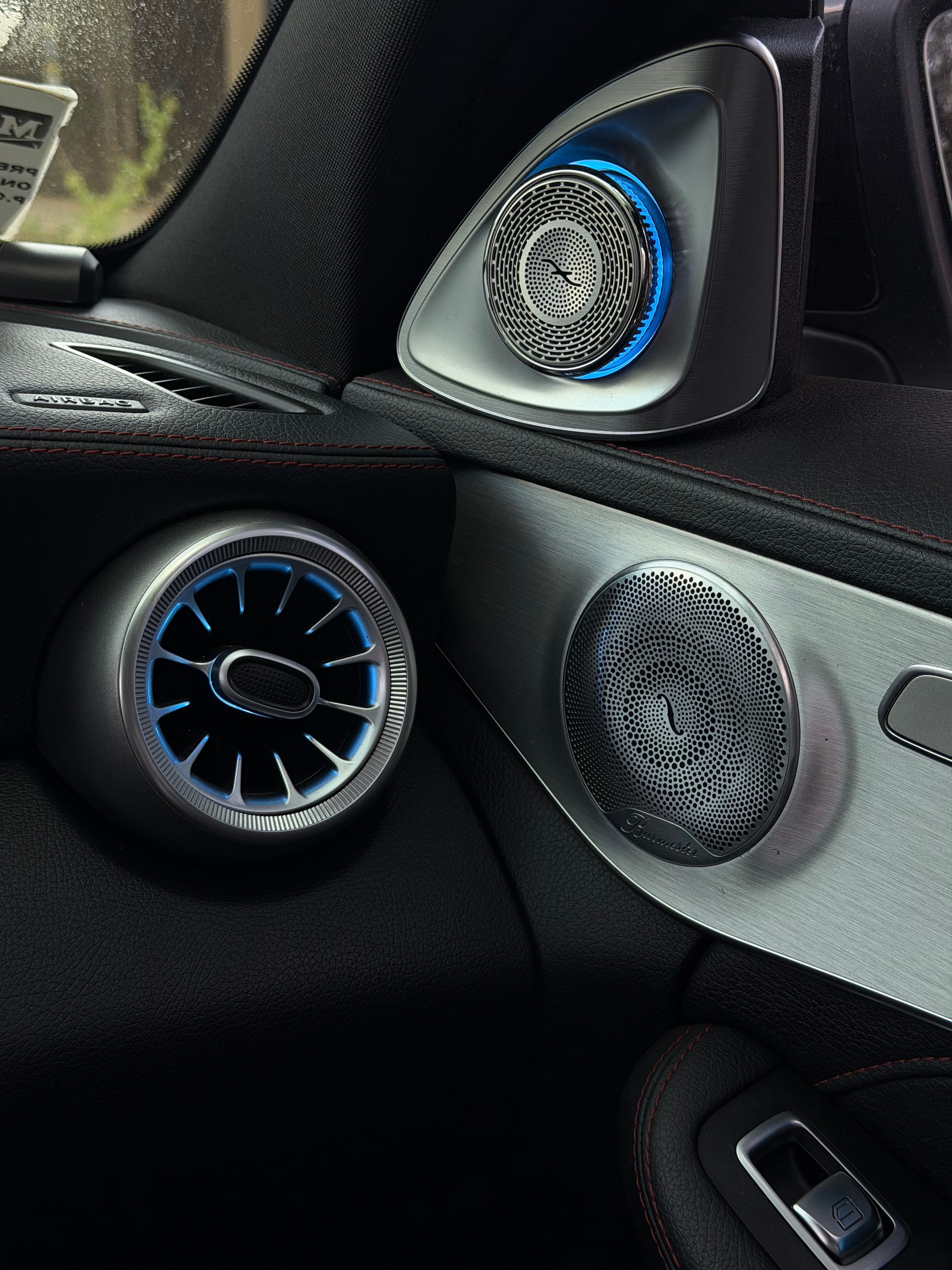 Nahaufnahme einer Mercedes-Tür mit Burmester Front System und blauer Ambientebeleuchtung im Dunkeln